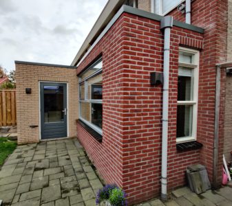 Uitbouw van een woning met nieuwe bijkeuken en extra ruimte.